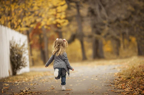 스웨터와 청바지를 금발의 곱슬머리를 스타일로 여학생은 뒷모습으로 노점을 달리고 — 스톡 사진