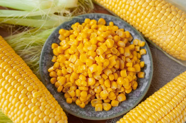 plate of canned crumbly corn and peeled cobs around it