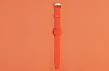 Turuncu arkaplanda manyetik sensörü olan turuncu silikon saat. Monokrom görüntüsü. Sağlıklı yaşam tarzınız, sağlığınıza dikkat edin.