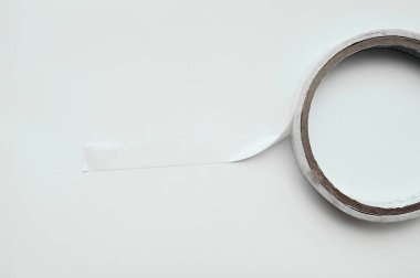 Beyaz ve temiz bir arkaplan üzerine yapıştırılmış beyaz çift taraflı bant rulo