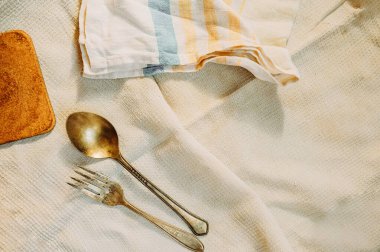 Eski, çizilmiş eski metal çatal bıçak takımı, büyük bir kaşık ve çatal eski bir waffle peçetesine..