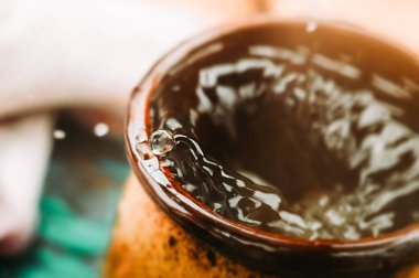 Kahverengi seramik bardakta bir damla su. Makro su atışı. seçici odak, asbtraction