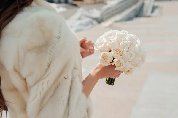 少女の手に新鮮な同じバラのホワイトブライダル花束 恋人たちの手が背景にある — ストック写真
