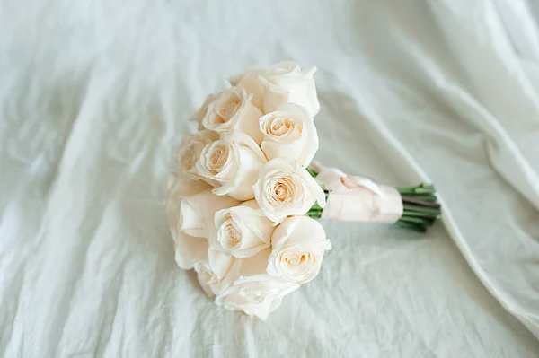 乳白色のコットンファブリック上の白い純粋な新鮮な同じバラの結婚式の花束 上からの眺め テキストのスペース 招待状のレイアウト — ストック写真