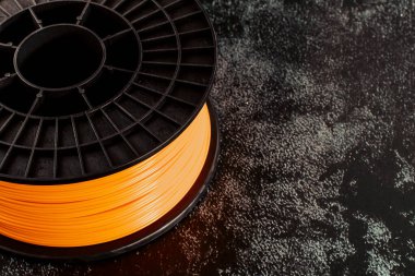 3D baskı için iplik. Parlak termoplastik neon turuncu, renk. Makara yatay görünümü.