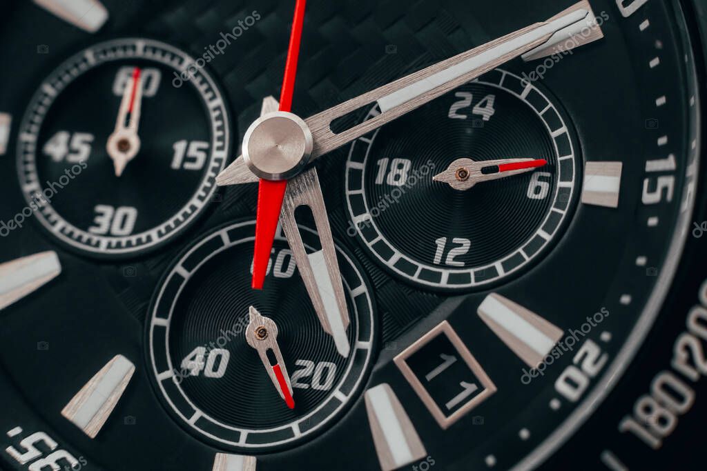 Black watch case and dial. Wristwatch with red arrows close-up. Macro