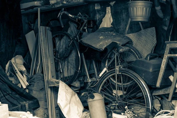 Old abandoned bike in a pile of rubbish. Black and white image