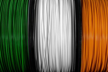 Ireland flag of the coils for 3D printer. Filament for 3d printing. Bright thermoplastic of green, white and orange colors. Flag colors clipart