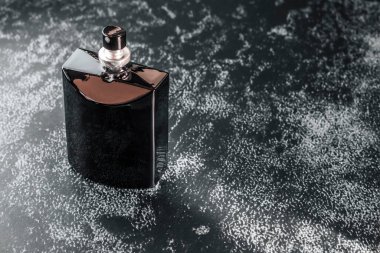 İçinde erkek parfümü olan siyah bir şişe. Siyah parfüm şişesinin bir kopyası. Karanlık ve boş arka planda..