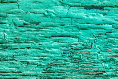 Duvarın yüzeyindeki eski çatlak boya. Çatlaklarda renkli boya. Mavi ve yeşil kurumuş boya..