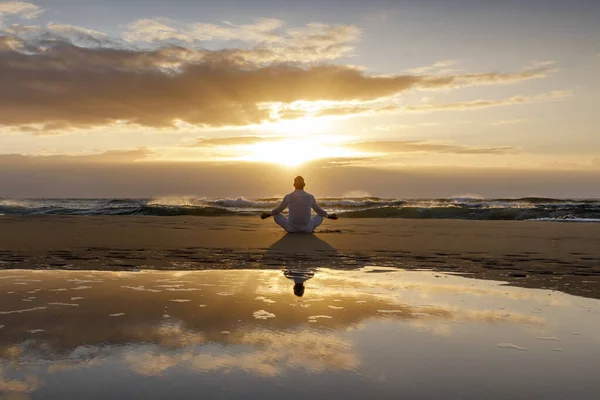 yoga meditation silhouette lotus sunrise beach, water reflection of man in yoga pose, mindfulness wellbeing concept