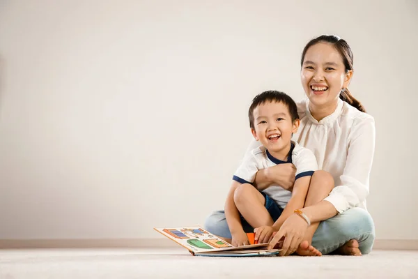 Asian mother and child reading story book together