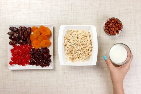 Kız süt yulaf ezmesi dökmek için aldı. Yararlı ve sağlıklı bir kahvaltı. Beyaz arka plan.