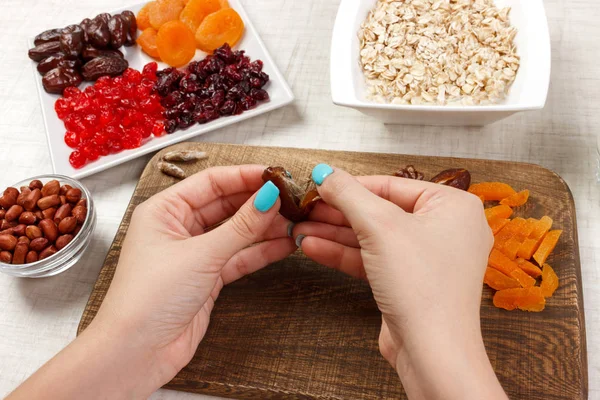 Kız ona kahvaltı hazırlıyor. Kız onun tarihi meyve yulaf lapası bir kesme tahtası üzerinde temizler. Yararlı ve sağlıklı bir kahvaltı. açık renkli.