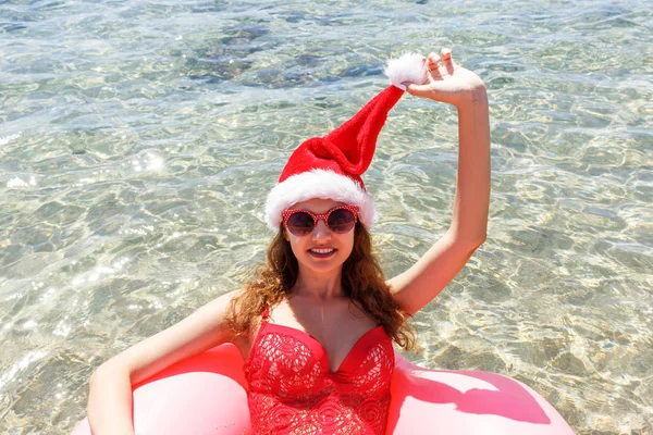 Красивая Молодая Женщина Рождественской Шляпе Розовым Кругом Отдыха Голубом Море — стоковое фото