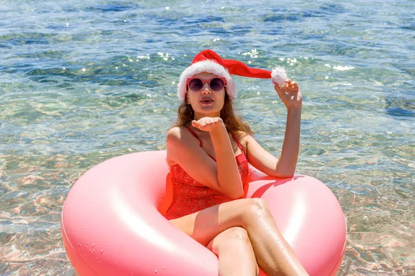 Wanita Muda Cantik Topi Santa Claus Bersantai Atas Donat Tiup — Stok Foto