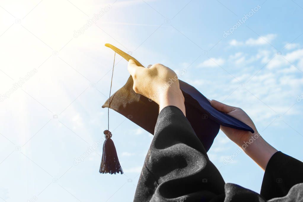 Graduate celebrating with cap in her hand,feeling so proud and happiness in Commencement day.