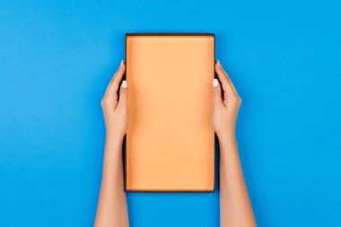 Açık kutu mavi arka plan üzerinde tutan eller kadın.