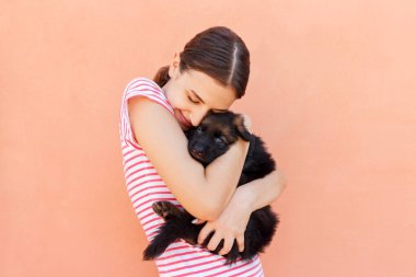 Güzel kız şirin küçük köpek sıkı sarılma.