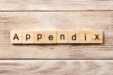 Apandisit kelimesi tahta bloğa yazılmış. Tablo üzerinde ek metin, konsept.