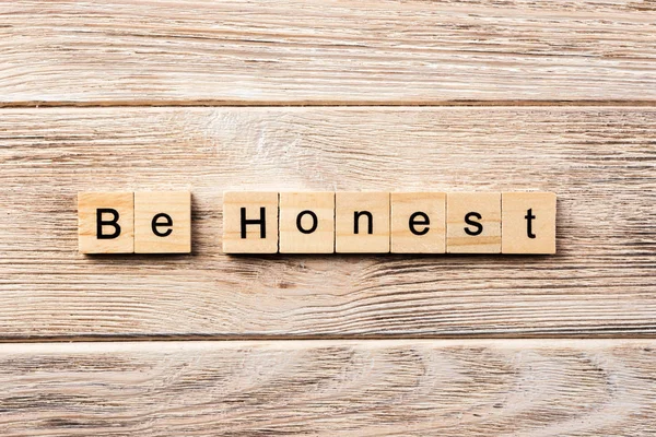 be honest word written on wood block. be honest text on table, concept.