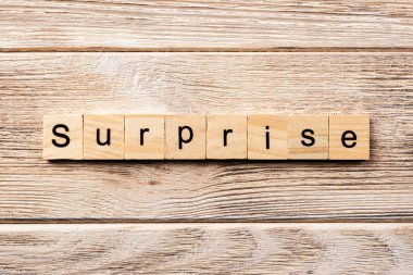Tahta blokta sürpriz kelime yazıyor. Masada sürpriz metin, konsept.