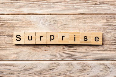 Tahta blokta sürpriz kelime yazıyor. Masada sürpriz metin, konsept.