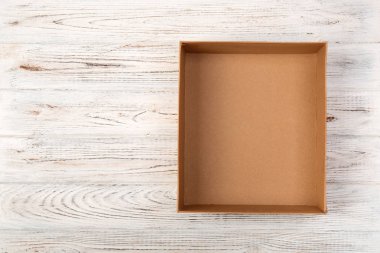 Ahşap arka plan, üstten görünüm üzerinde kahverengi boş karton kutu açıldı.