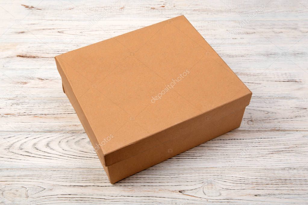 Brown closed cardboard box on a wooden background. top view, blank for you design.