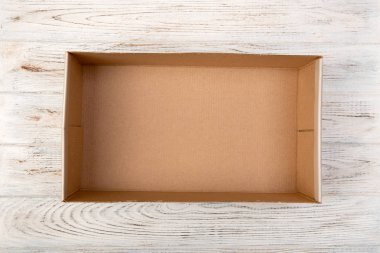 Ahşap arka plan, üstten görünüm üzerinde kahverengi boş karton kutu açıldı.