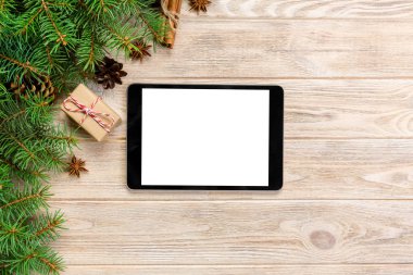 Dijital tablet kadar app tanıtımı için rustik Noel ahşap arka plan süslemeleri ile alay. kopya alanı ile üstten görünüm.