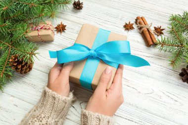 Erkek geri dönüşümlü kağıt beyaz ahşap masa arka plan üzerinde tutarak el yapımı mevcut kutusunda eller. Noel hazırlık kavramı, arka plan kaydırma Hediyelik.