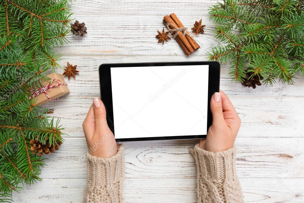 woman hands using tablet computer on wooden table bachground. cristmas shopping time. Happy Christmas mock up background, top view.