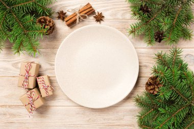 Boş beyaz mat plaka ahşap arka plan üzerinde. Noel dekorasyonu ile çanak yuvarlak. Yeni yıl kavramı.