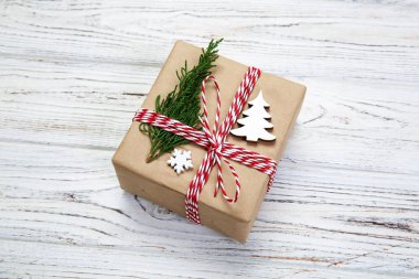 Noel hediye kutusu şerit rustik arka plan üzerinde kopya alanı ile üstten görünüm ile geri dönüşümlü kağıt sarılı. Tatil kavramı.