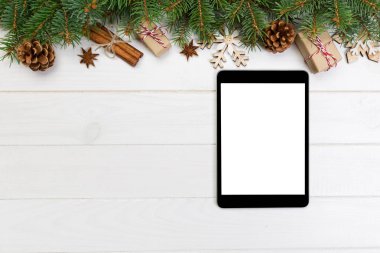 Dijital tablet kadar app tanıtımı için rustik Noel ahşap arka plan süslemeleri ile alay. kopya alanı ile üstten görünüm.