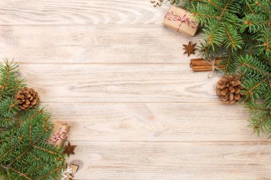 Noel köknar ağacı ve hediye kutusu ahşap masa üzerinde arka plan. Tasarımınız için kopya alanı ile üstten görünüm.