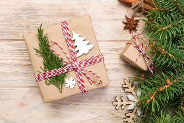 Noel köknar ağacı ve hediye kutusu ahşap masa üzerinde arka plan. Tasarımınız için kopya alanı ile üstten görünüm.