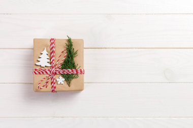 hediye kutusu Noel dekorasyonu ile şerit yay ile geri dönüşümlü kağıt sarılı. Ahşap masa arka plan, kopya alanı.