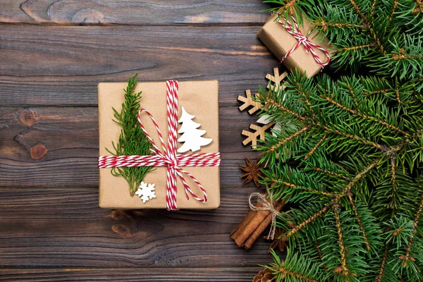 Noel köknar ağacı ve hediye kutusu ahşap masa üzerinde arka plan. Tasarımınız için kopya alanı ile üstten görünüm.