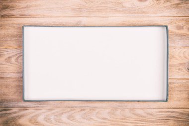 Ahşap zemin üzerine karton kutuyu açtın. Vintage, tonda üstten görünüm.