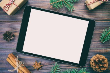 Dijital tablet kadar app tanıtımı için rustik Noel ahşap arka plan süslemeleri ile alay. «Ana sayfa» görünümü vintage, tonda kopya alanı ile.