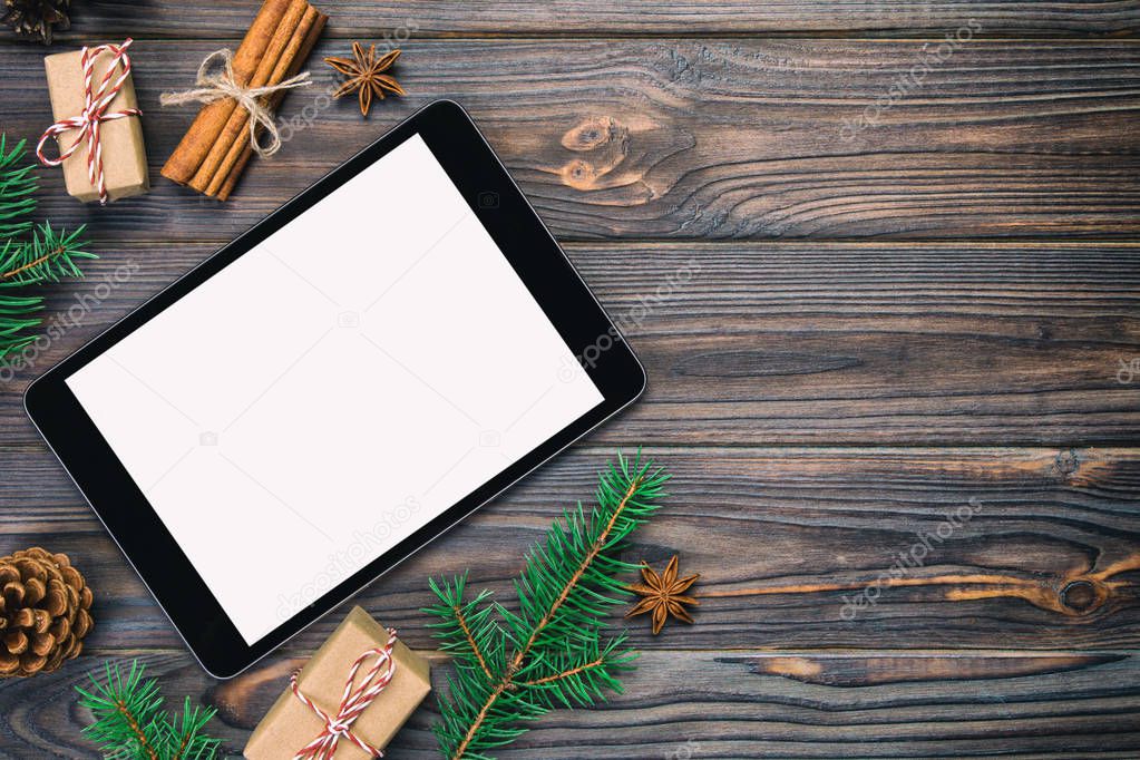 Digital tablet mock up with rustic vintage, toned Christmas wooden background decorations for app presentation. top view with copy space.