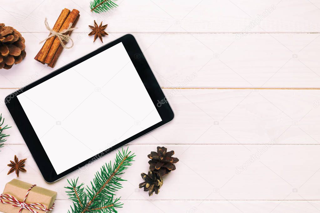 Digital tablet mock up with rustic Christmas wooden background decorations for app presentation. top view vintage, toned with copy space.