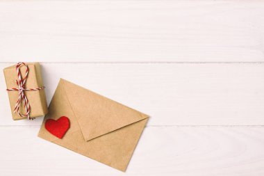 Kırmızı kalp Valentine. Sarılı bir kağıt parsel bağlı tonda, vintage. Hediye kutusu ile kırmızı bir kalp ile kraft kağıt sarılı.