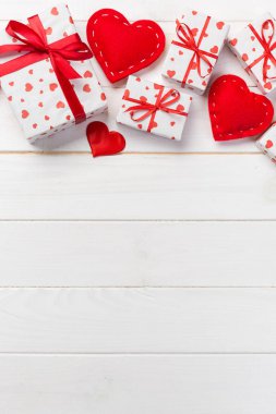Sevgililer veya diğer tatil el yapımı mevcut kağıt ile tatil sarmalayıcı kırmızı kalpler ve hediye kutusunda. Tasarım için kopya alanı görünümüyle Beyaz ahşap masa üstü, boş alanı kutusu hediye sunmak.