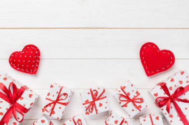 Sevgililer veya diğer tatil el yapımı mevcut kağıt ile tatil sarmalayıcı kırmızı kalpler ve hediye kutusunda. Tasarım için kopya alanı görünümüyle Beyaz ahşap masa üstü, boş alanı kutusu hediye sunmak.