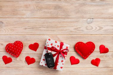 Sevgililer veya kağıt kırmızı kalpler ile diğer tatil el yapımı hediye, Araba anahtarları ve hediye tatil sunulu liste kutusunda. Tasarım için turuncu ahşap masa üstten görünüm kopya alanı ile boş alanı kutusu hediye.