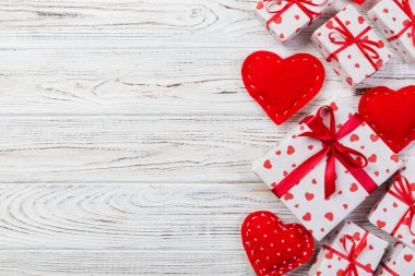 Sevgililer veya diğer tatil el yapımı mevcut kağıt ile tatil sarmalayıcı kırmızı kalpler ve hediye kutusunda. Tasarım için kopya alanı görünümüyle Beyaz ahşap masa üstü, boş alanı hediye kutusu.