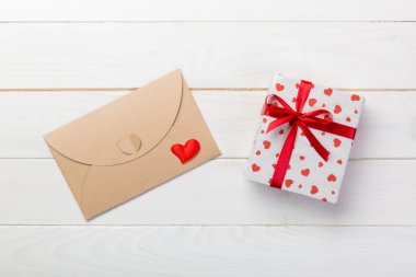 Beyaz ahşap arka plan üzerinde kırmızı kalp ve hediye kutusu ile zarf posta. Sevgililer günü kartı, aşk veya kavramı tebrik düğün.